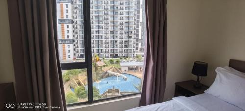a hotel room with a view of a pool from a window at Pool view + water theme park @swiss garden residence in Kuantan