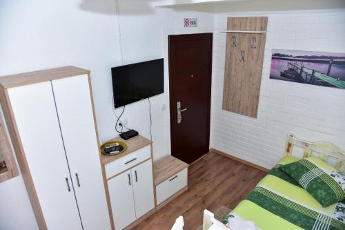 a small room with a bed and a television at Apartmani Koko in Banja Luka