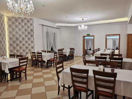a dining room with tables and chairs and a chandelier at Zajazd Pod Jesionami in Nisko