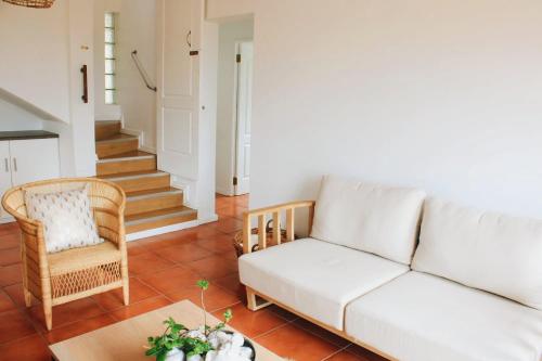 a living room with a white couch and a chair at Struispaleis in Struisbaai