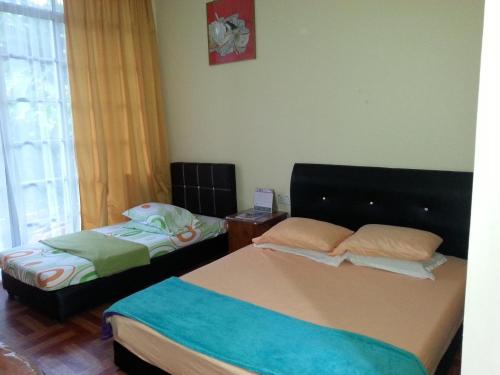 1 dormitorio con 2 camas y ventana en Badul Homestay en Musi