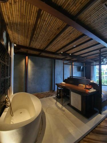 a large bathroom with a tub and a piano at MINH - CASA in Hoi An