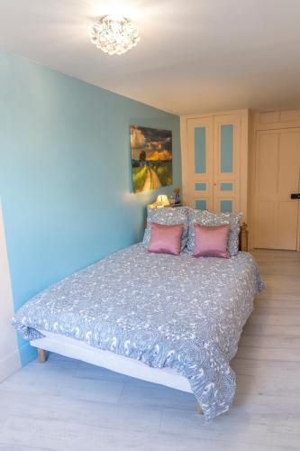a bedroom with a large bed with two pink pillows at Garage, 2 chambres, balnéo, 2 SDB, 2WC, vue sur les monuments in Le Puy en Velay