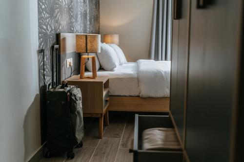 a hotel room with a bed and a suitcase at Ta' Tereza In Manwel Dimech in Sliema