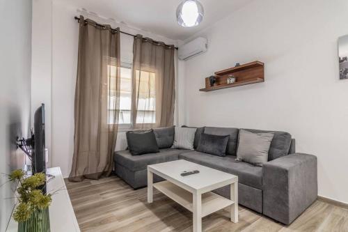 ein Wohnzimmer mit einem Sofa und einem Tisch in der Unterkunft Warm and cozy in Athen
