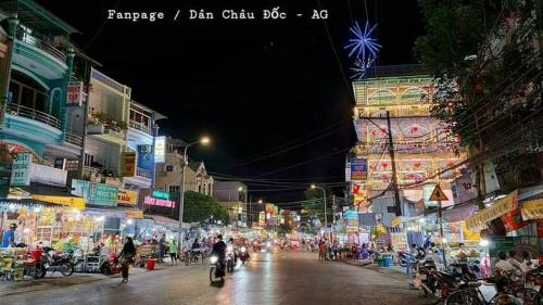 a city street at night with people riding motorcycles at Phú Thông in Chau Doc