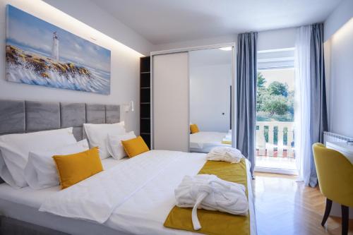 a bedroom with two beds and a large window at Elais Luxury Residence in Podstrana