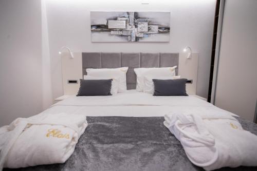 a bedroom with a large bed with white sheets and pillows at Elais Luxury Residence in Podstrana