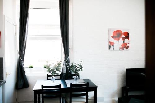 a dining room with a table and chairs and a window at The Holt in Leicester