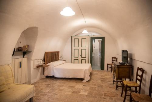a bedroom with a bed and a table and chairs at Masseria Trotta B&B in Fasano