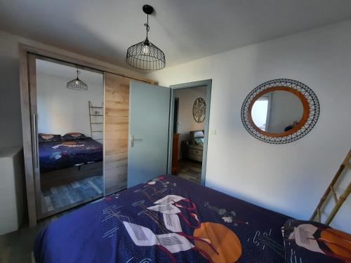 F2 Rénové Centre de Haguenau في آغينو: غرفة نوم مع سرير ومرآة على الحائط