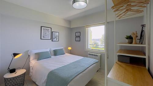 ein kleines Schlafzimmer mit einem Bett und einem Fenster in der Unterkunft Apartamento Playa Lago in A Coruña