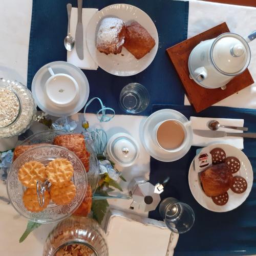 a table with plates of food and cups of coffee at B&B La Foglia Verde in Massa
