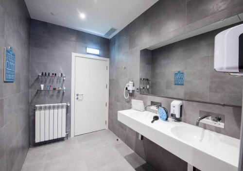 a bathroom with two sinks and a white door at The Central House Porto Ribeira in Porto