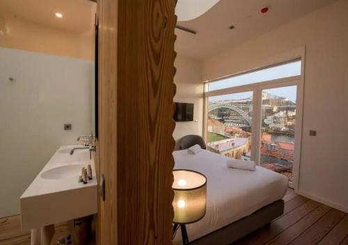 a bedroom with a bed and a sink and a window at The Central House Porto Ribeira in Porto