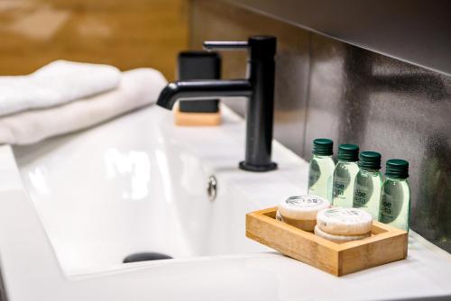 a bathroom sink with three bottles of detergent on it at Wójcik SPA - Krynica Zdrój in Krynica Zdrój