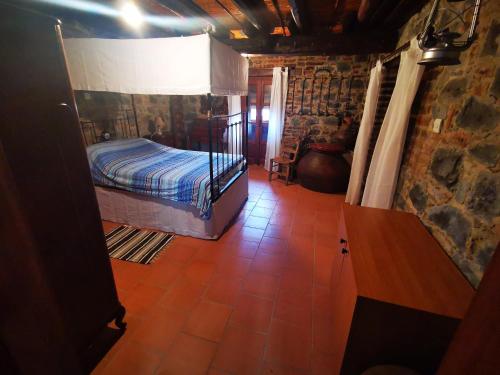 1 dormitorio con 1 cama en una habitación de piedra en The cave apartment, en Potamitissa