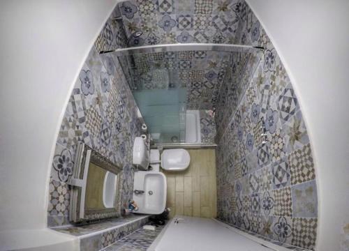 bagno con lavandino, specchio e piastrelle di Home Genoa Hostel a Genova