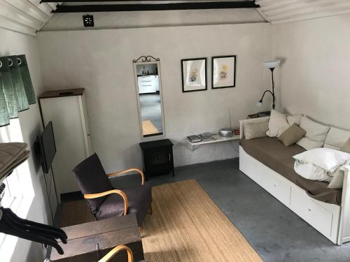 a bedroom with a bed and a chair and a mirror at Stallet på Skårby in Ystad