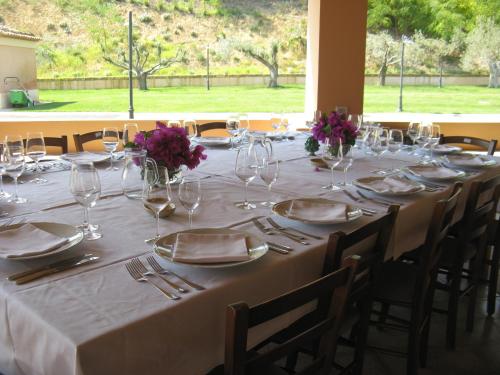 a long table with glasses and plates and flowers on it at Nanfro Resort - Masseria Spaccaforno in Caltagirone