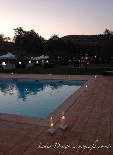 a swimming pool with candles in the middle of it at Nanfro Resort - Masseria Spaccaforno in Caltagirone