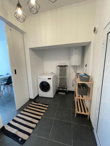 a kitchen with a washer and dryer on a tile floor at Arco´s Apartment 1 in Ponta Delgada