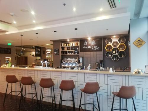 a bar with brown stools in a restaurant at Holiday Inn Trnava by IHG in Trnava