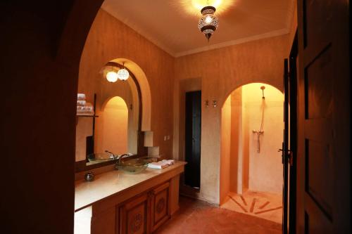 y baño con lavabo y espejo. en Le petit Château des Anges, en Marrakech