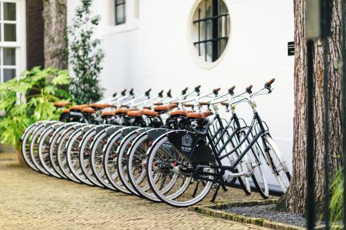 Une rangée de vélos garés à côté d'un bâtiment dans l'établissement The Dylan Amsterdam - The Leading Hotels of the World, à Amsterdam