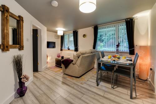 a living room with a table and a couch at 1 Bedroom Swinley Apartment l Free Parking l Wigan Royal Infirmary l Haigh Hall l Central Location in Wigan