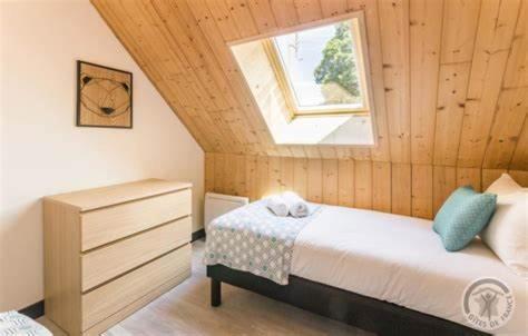 a bedroom with a bed and a window at L'Âme du Gourmand in Pontorson