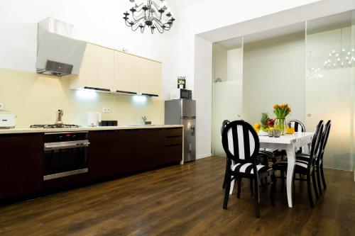 HOUSEHOST Apartment: Bogusławskiego Street في كراكوف: مطبخ مع طاولة وكراسي في مطبخ