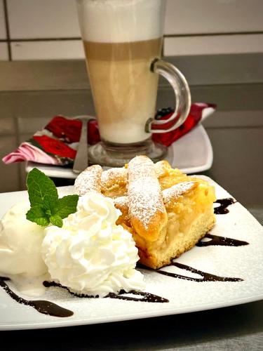 a plate of food with whipped cream and a drink at Hotel Dowhań in Nowe