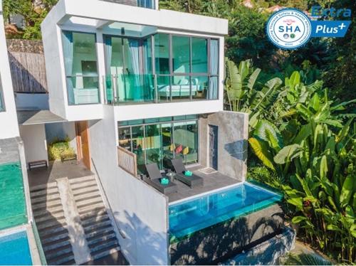 a house with a swimming pool next to a villa at Baan Saint-Tropez Seaview Villas Kata Beach in Kata Beach