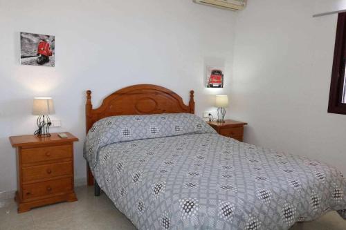 ein Schlafzimmer mit einem Bett und zwei Nachttischen in der Unterkunft 29a zafiro 1ª línea de playa in Calpe