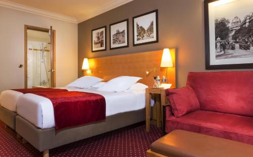 a hotel room with a bed and a red couch at Royal Saint Michel in Paris