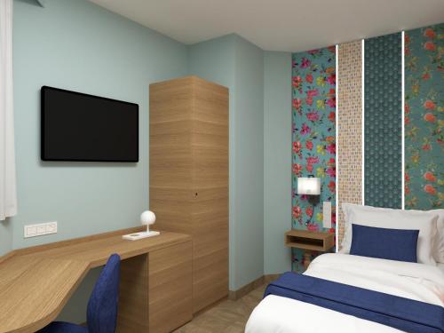 a bedroom with a bed and a tv on the wall at Parc Hotel Flora S in Riva del Garda