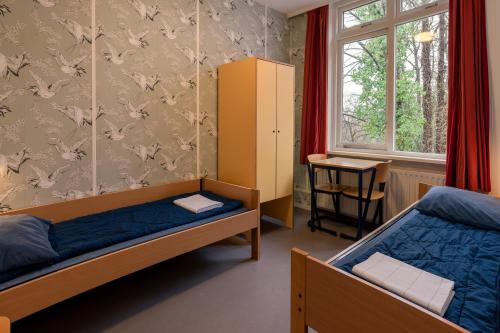 a bedroom with two bunk beds and a window at Stayokay Hostel Arnhem in Arnhem