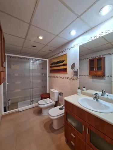 ein Badezimmer mit 2 WCs, einem Waschbecken und einer Dusche in der Unterkunft Dos Torres Boromir - Ubicación en el Corazón de la Ciudad in Saragossa