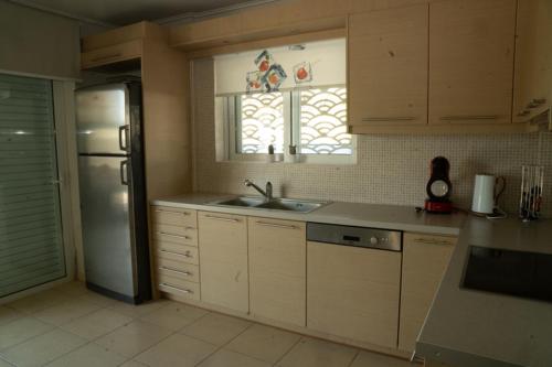 a kitchen with a sink and a refrigerator and a window at Luxury heated pool Villa in Lagonissi