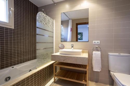 a bathroom with a sink and a toilet and a mirror at Villa Playera in Alcudia