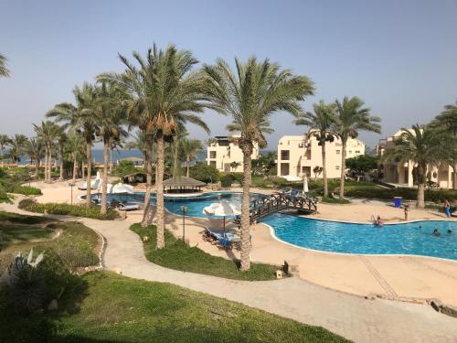 an aerial view of a resort swimming pool with palm trees at Chalet with Roof at Laguna Bay- Ain Sokhna - شالية غرفتين مكيف بالكامل بالرووف قرية لاجونا باي - العين السخنة in Ain Sokhna