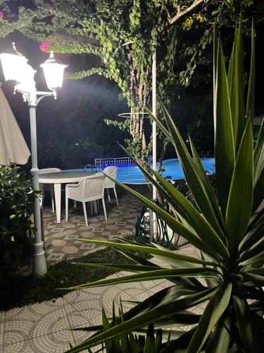 a patio with a table and chairs next to a pool at BELKA GOLF RESİDENCE Deluxe apt Poolside BELEK in Belek