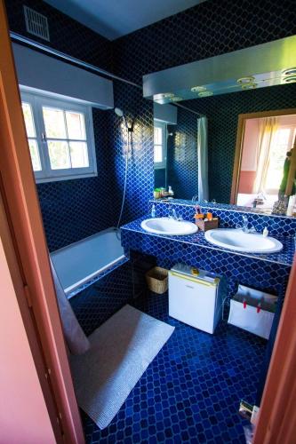 a bathroom with two sinks and a tub and a mirror at Les jardins de Beaumont in Hem