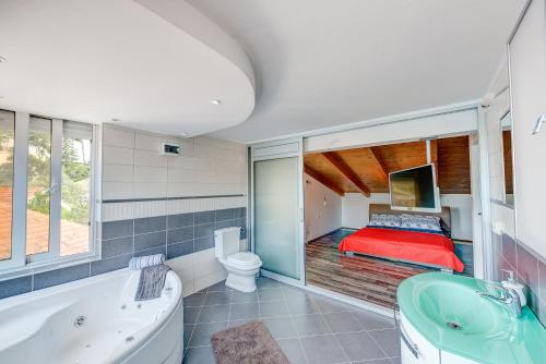 a bathroom with a tub and a bedroom with a bed at Veli rat apartments in Savar