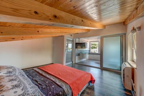 a bedroom with wooden ceilings and a bed with a red blanket at Veli rat apartments in Savar