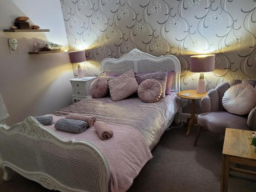 1 dormitorio con 1 cama blanca con almohadas y silla en Siobhan's abode 2 Deluxe doubles n large single NO PETS, en Swindon
