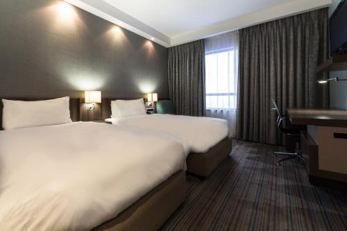Habitación de hotel con 2 camas y escritorio en Holiday Inn Express Durban - Umhlanga, an IHG Hotel, en Durban