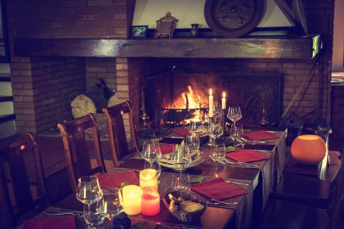 a table in front of a fireplace with a table set with candles at La Tagliolina in Monteveglio