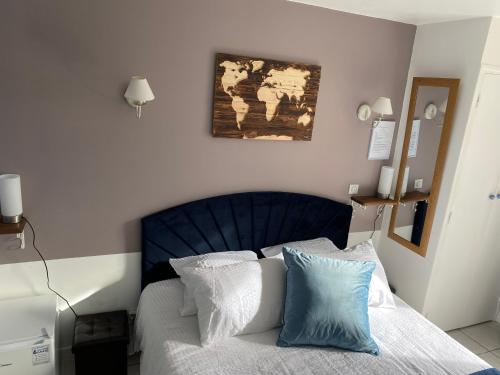 a bedroom with a bed with a blue head board at Le Domaine du Gravier in Gramat